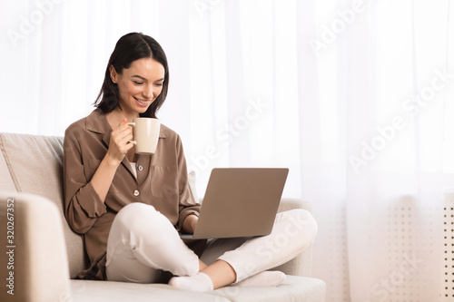 Young woman using laptop sitting on the couch