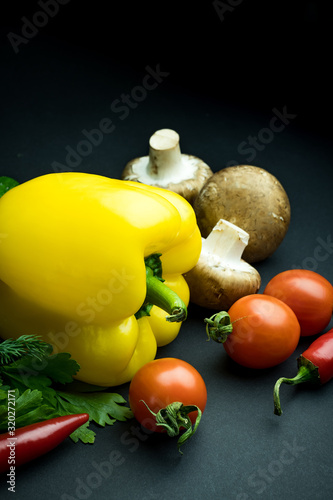 Close up view of bright organic vegetables on black background with copy space