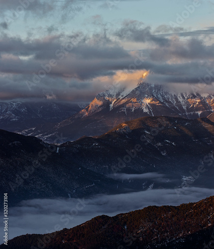 Amanecer con vista a la cima de una montaña nevada photo