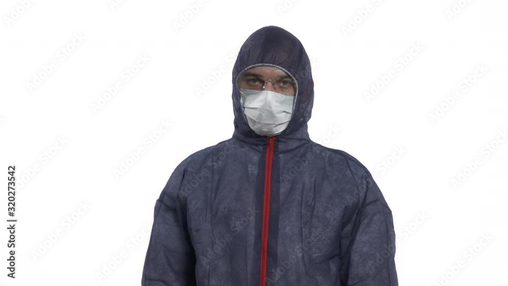 Portrait of a caucasian man in protective suit, mask and glasses looking at camera. Showing to move forward with his hands. Move to me gesture. Studio, isolated on white background. Portrait of a caucasian man in protective suit, mask and glasses looking at camera. Showing to move forward with his hands. Move to me gesture. Studio, isolated on white background.