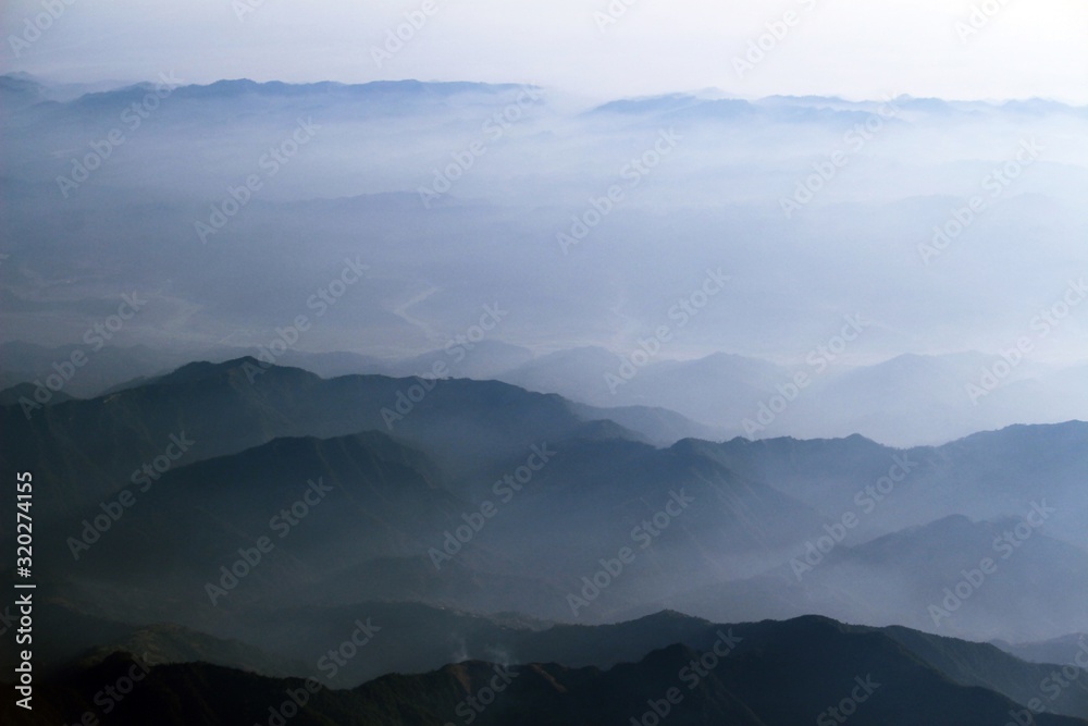 White fog over high dark green mountains range, a beautiful landscape