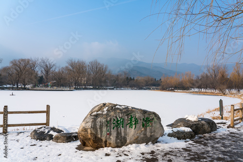 Chengjing lake of Beijing Botanical Garden after snow in winter. Chinese Font Translation on Stone: Clean and Clear Lake photo