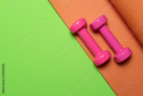 dumbbell and yoga mat on table, fitness healthy and sport concept