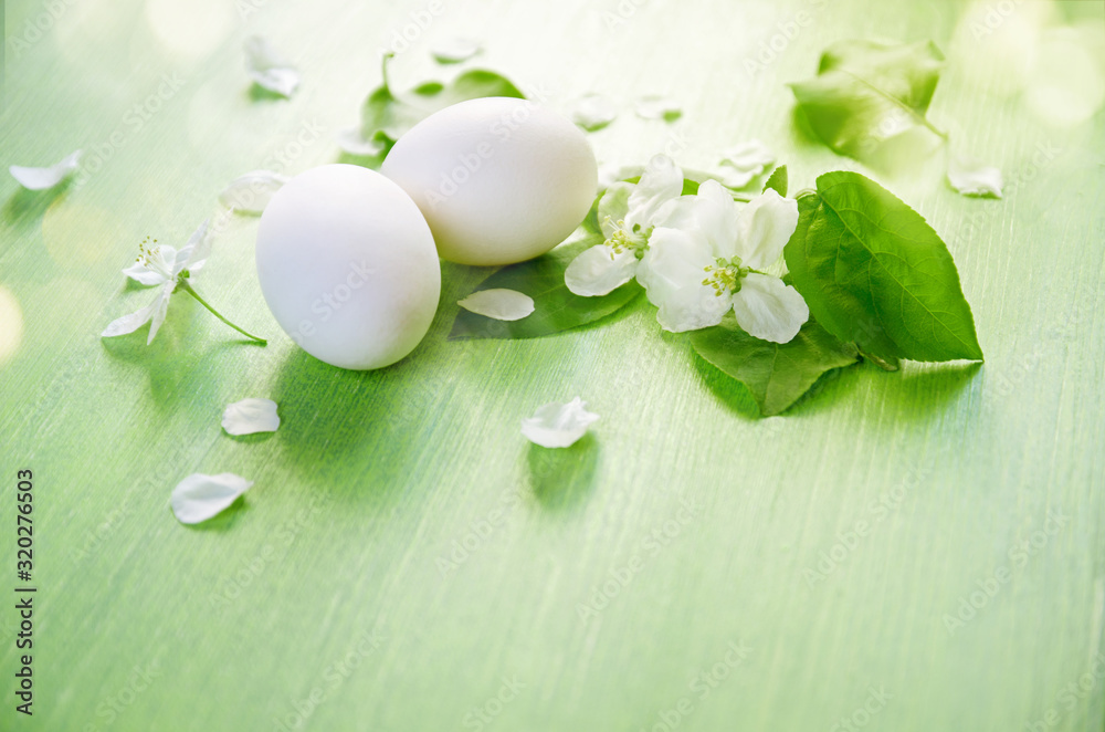 Easter holiday background. White eggs, of an Apple tree flowers and green leaves on a wooden table. Easter holiday background. White eggs, of an Apple tree flowers and green leaves on a wooden table.