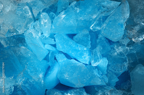 Pieces of crushed blue ice glass cracks background texture. close-up frozen water