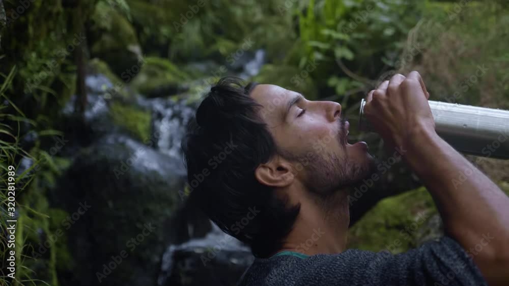 Madeira, Portugal - Male Tourist Drinking Water In His Tumbler In Slow Motion With Wonderful Scenery Of Clear Water Flowing On The Rocks - Closeup Shot