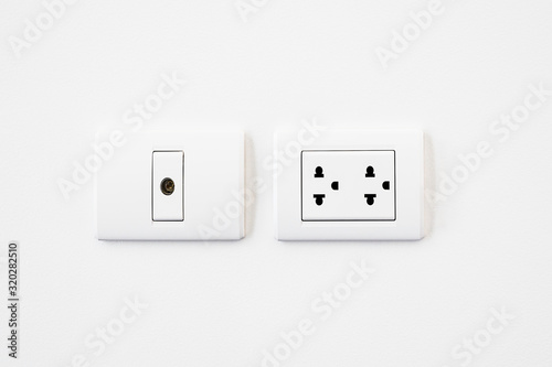 Television and electricity plug on white wall