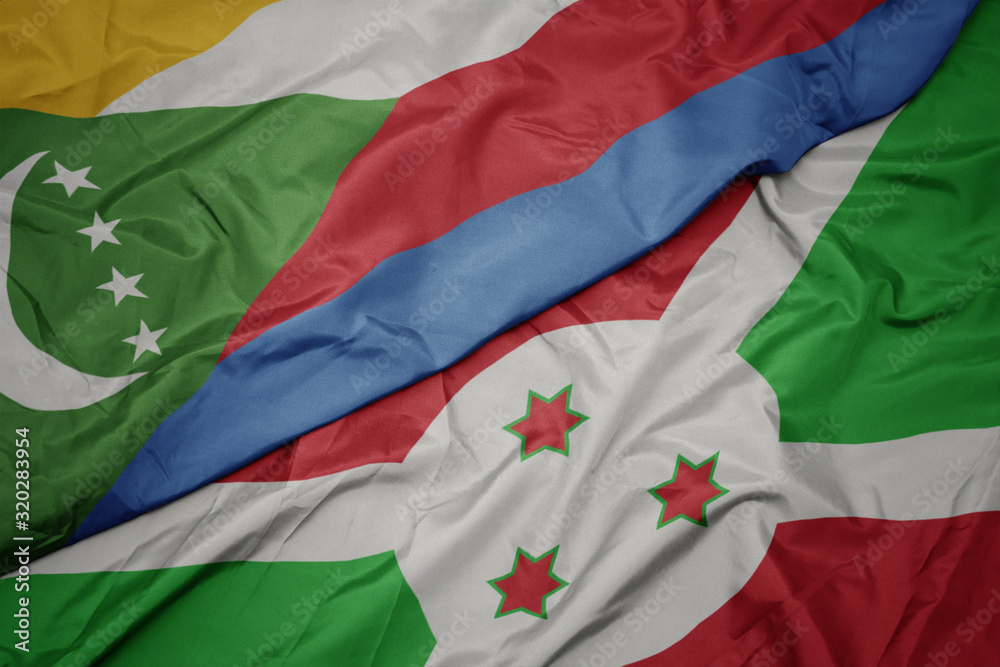 waving colorful flag of burundi and national flag of comoros.