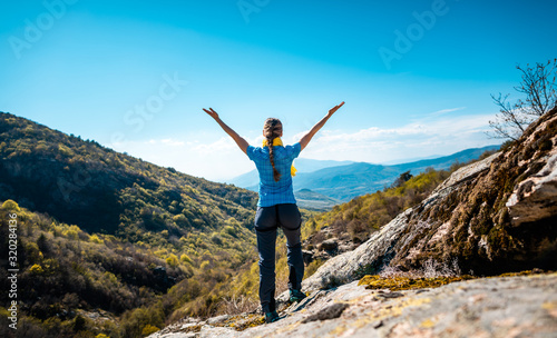 Hiking woman enjoying the freedom of a mountainous landscape © Kzenon