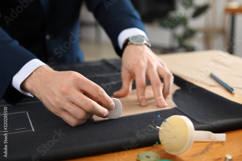 Young tailor working at tab...
