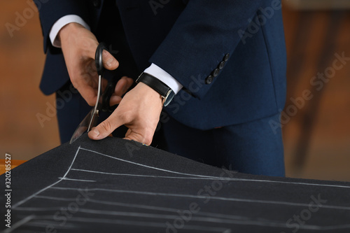 Young tailor working at tab...