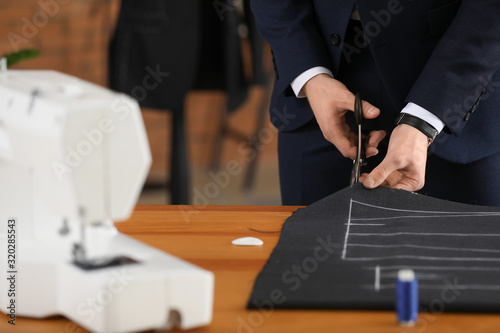 Young tailor working at tab...