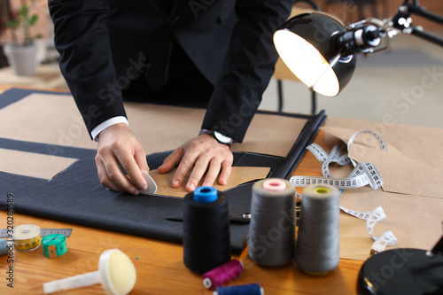 Young tailor working at tab...