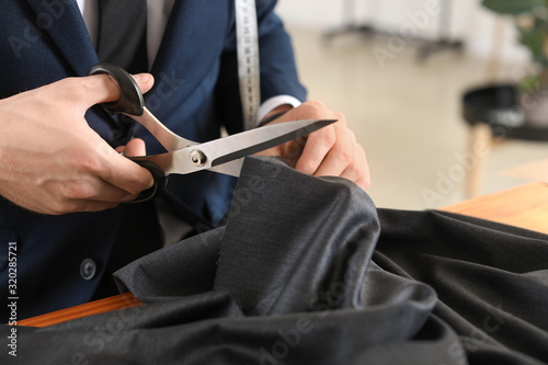 Young tailor working in atelier, closeup