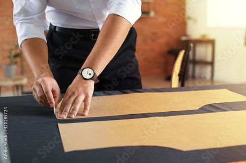 Young tailor working at tab...