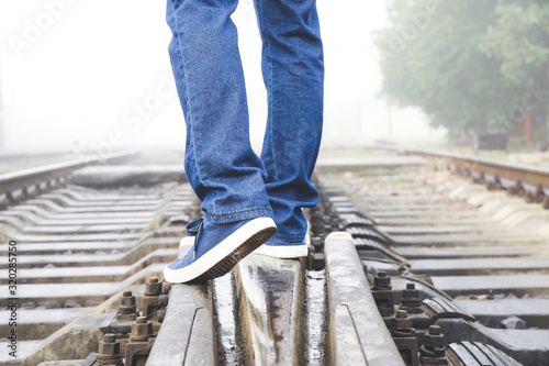 Young man going along railway track. Concept of choice