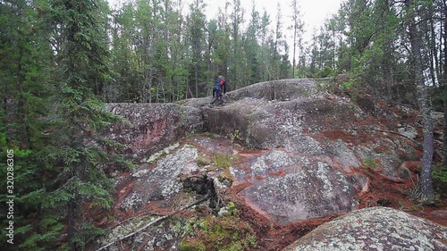 Man hiking on rocks in the wilderness photo