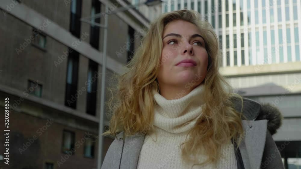 Low angle close up of a stylish blonde woman walking confidently in the city Low angle close up of a stylish blonde woman walking confidently in the city