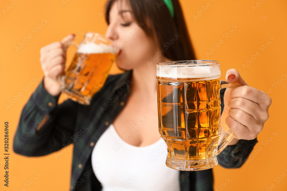 Funny young woman with beer on color background. St. Patrick's Day celebration Funny young woman with beer on color background. St. Patrick's Day celebration