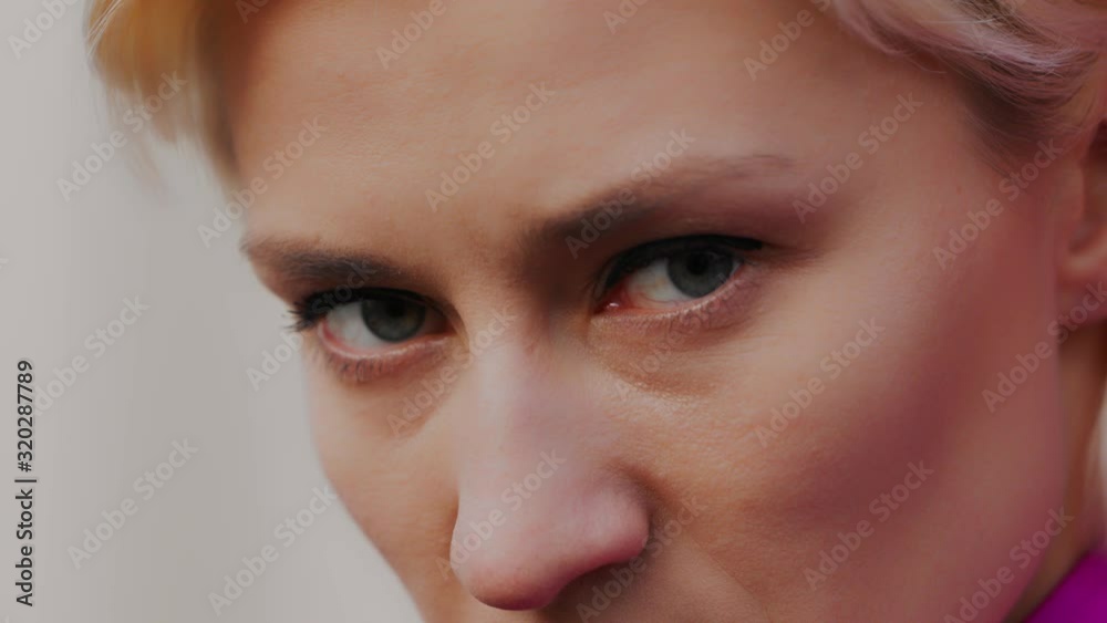Extreme close up shot of the green eyes of an angry woman. Serious scary look. Selective soft focus, isolated slow motion shot Extreme close up shot of the green eyes of an angry woman. Serious scary look. Selective soft focus, isolated slow motion shot