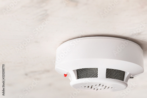 Modern smoke detector on ceiling