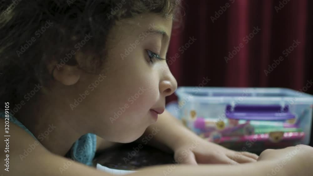 Close up portrait of a young female child coloring with crayon Close up portrait of a young female child coloring with crayon