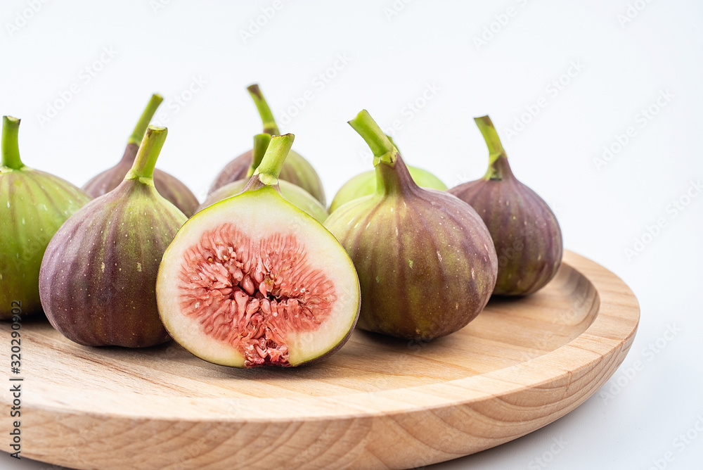 Obraz premium Fresh fruit figs on a saucer on white background