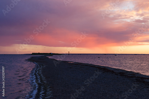Baltic sea rocky shore at colorful sunset. Long and narrow peninsula