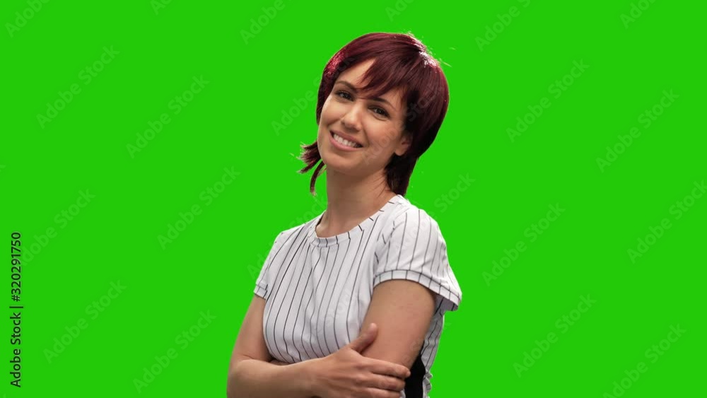 Beautiful smiling woman posing on green screen with arms crossed Beautiful smiling woman posing on green screen with arms crossed