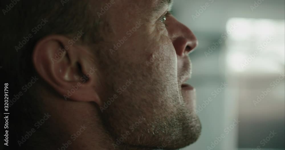 Side view of male bodybuilder's sweaty face while inside the gym during workout Side view of male bodybuilder's sweaty face while inside the gym during workout