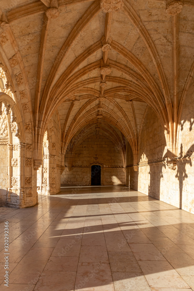 The sun entering between the arches of The Jeronimos Monastery in Lisbon, Portugal