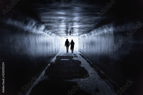 Silhouettes in a subway tunnel.Blue background