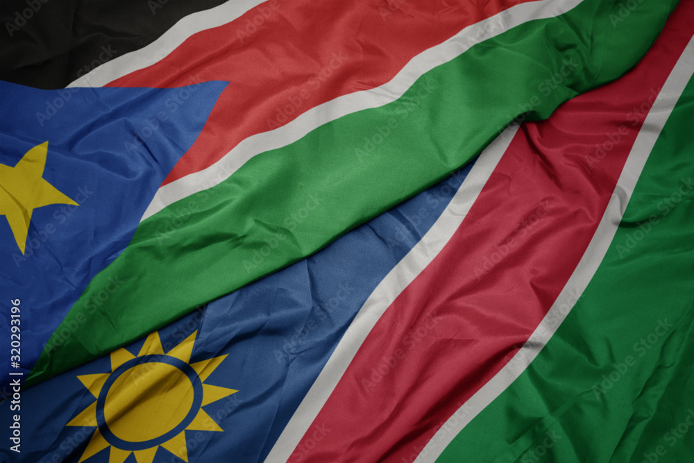 waving colorful flag of namibia and national flag of south sudan.