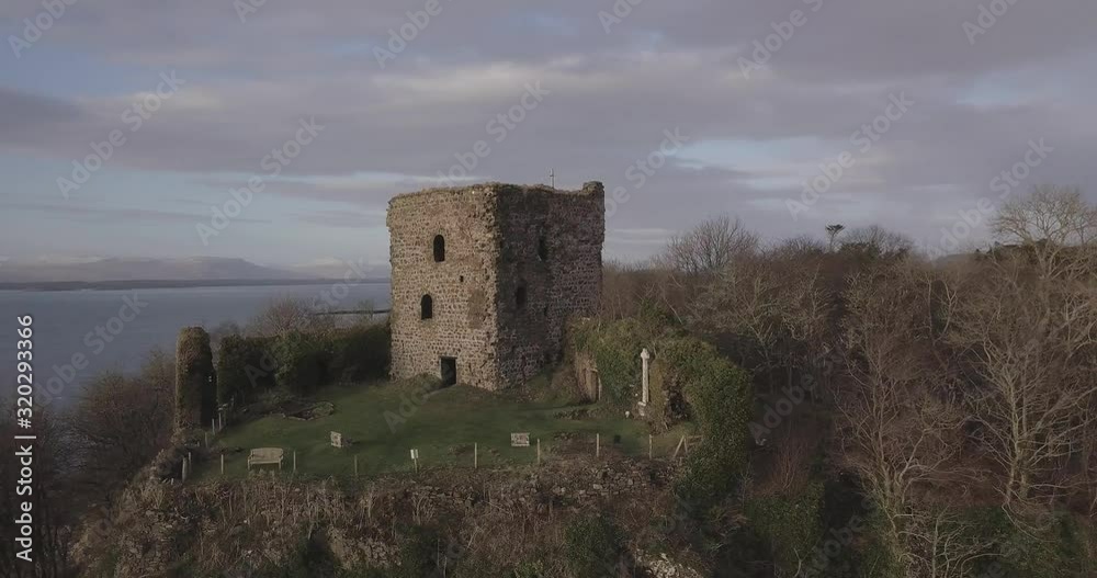 Aerial orbital shot of Dunollie Castle at sunset with the Island of Lismore in the background Aerial orbital shot of Dunollie Castle at sunset with the Island of Lismore in the background