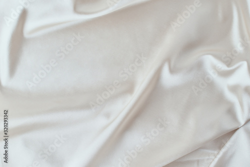 Gray silk background with a folds. Abstract texture of rippled satin surface