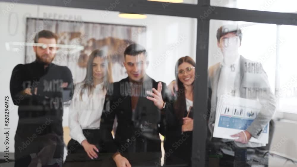 team of business people in office shooting through glass team of business people in office shooting through glass
