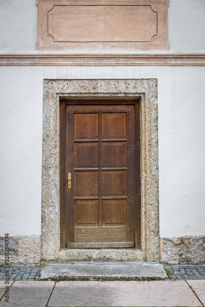 Old wooden door in white building in europe Old wooden door in white building in europe
