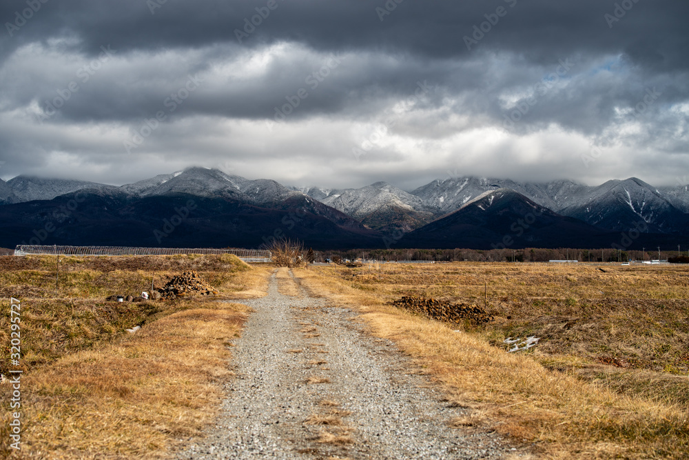Road leading to dark clouded mountains