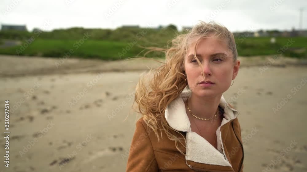 Dramatic camera pan around of young Caucasian girl exploring a sandy beach Dramatic camera pan around of young Caucasian girl exploring a sandy beach