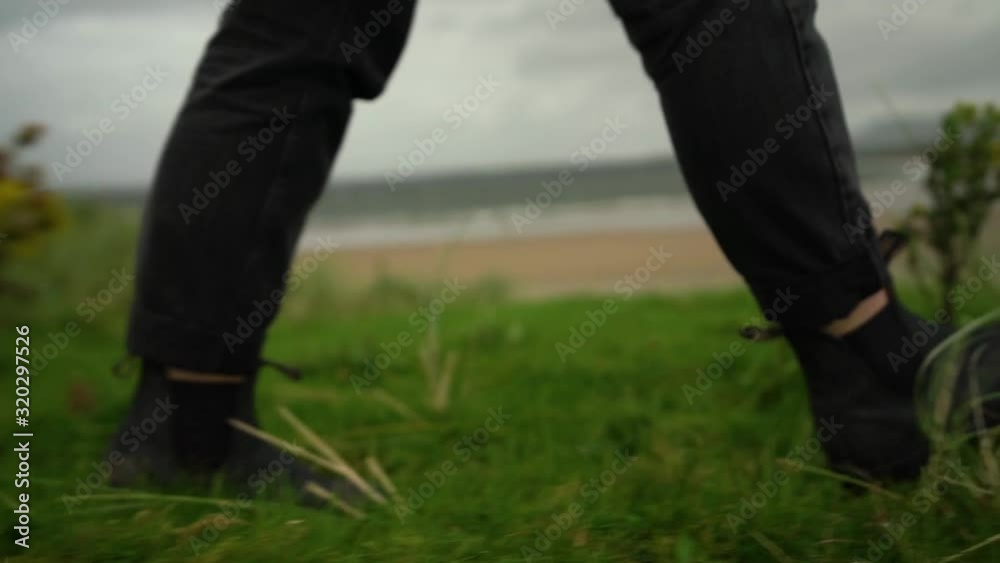 Close up of woman womans shoes walking through green grass Close up of woman womans shoes walking through green grass