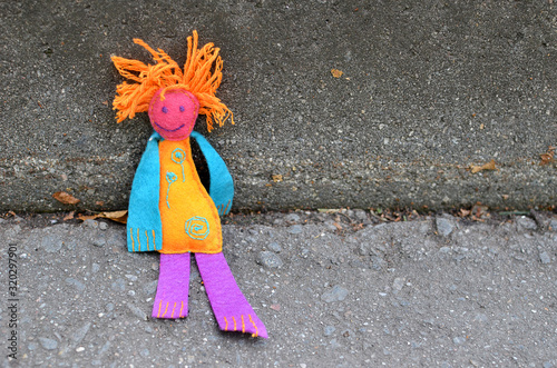 Handmade Colorful Shabby Felt doll  with red hair against concrete background