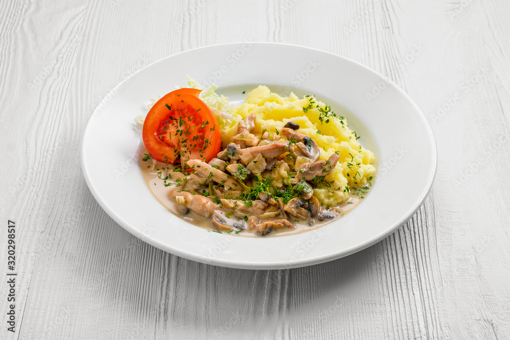 Plate with chicken goulash, mushroom, mashed potato and tomato cabbage salad Plate with chicken goulash, mushroom, mashed potato and tomato cabbage salad