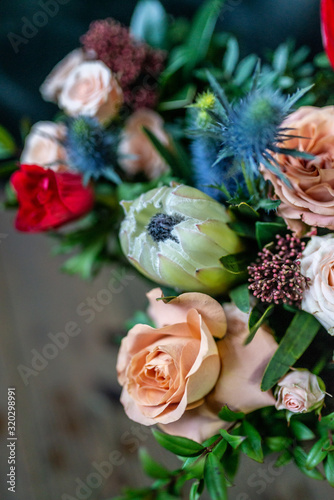 white flowers Protea rose anemone skimia eringium, bouquet in a watering can on the table, the most delicate flower in a bouquet of a flower shop photo