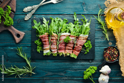 Prosciutto with arugula. Traditional Italian appetizer. Top view. Free copy space.