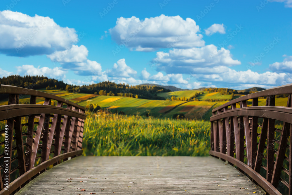 wooden bridge in mountain open field and bright blue cloudy sky landscape. wooden bridge in mountain open field and bright blue cloudy sky landscape.