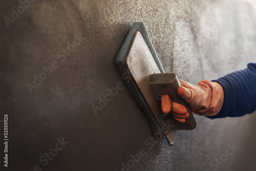 Fotografi Plastering concrete to create industrial worker wall background with plastering