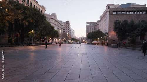 Sunrise walk in the streets of Barcelona while birds flying around photo