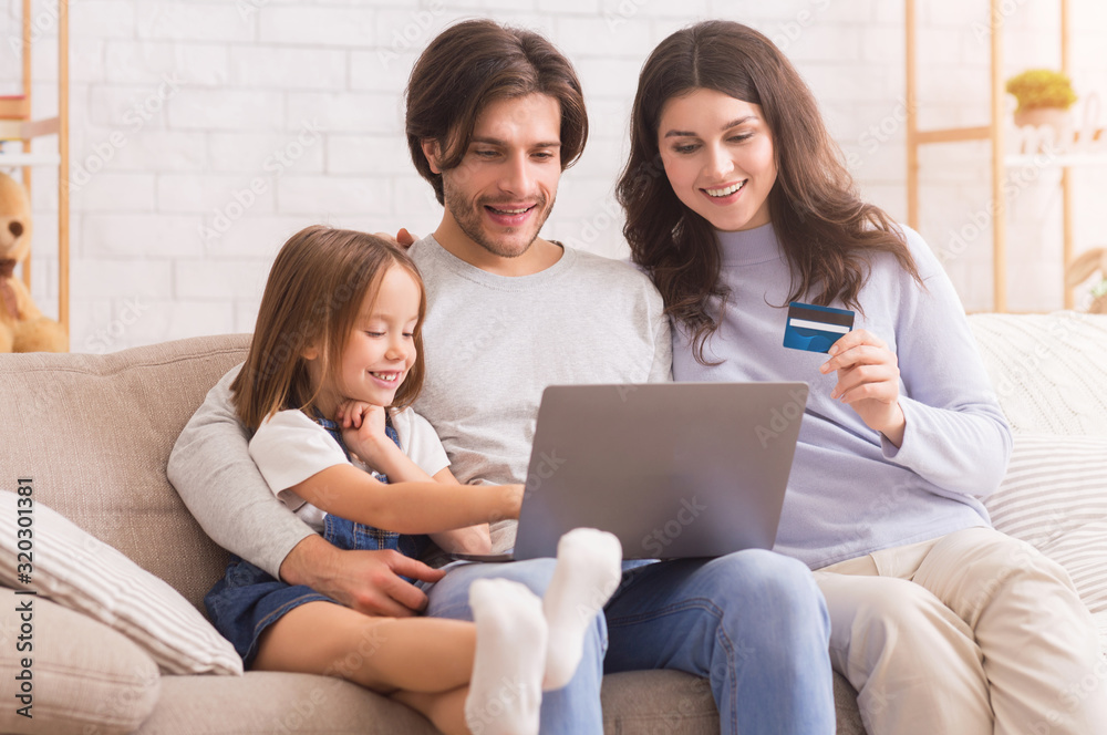 Cheerful Caucasian Family Sitting On Sofa With Laptop And Credit Card