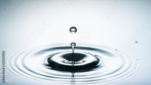 Close-up of a water drop falling on water surface