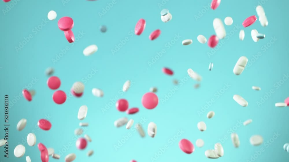 Super slow motion of falling mixed pills on blue background. Filmed on high speed cinema slow motion camera, 1000fps. Super slow motion of falling mixed pills on blue background. Filmed on high speed cinema slow motion camera, 1000fps.